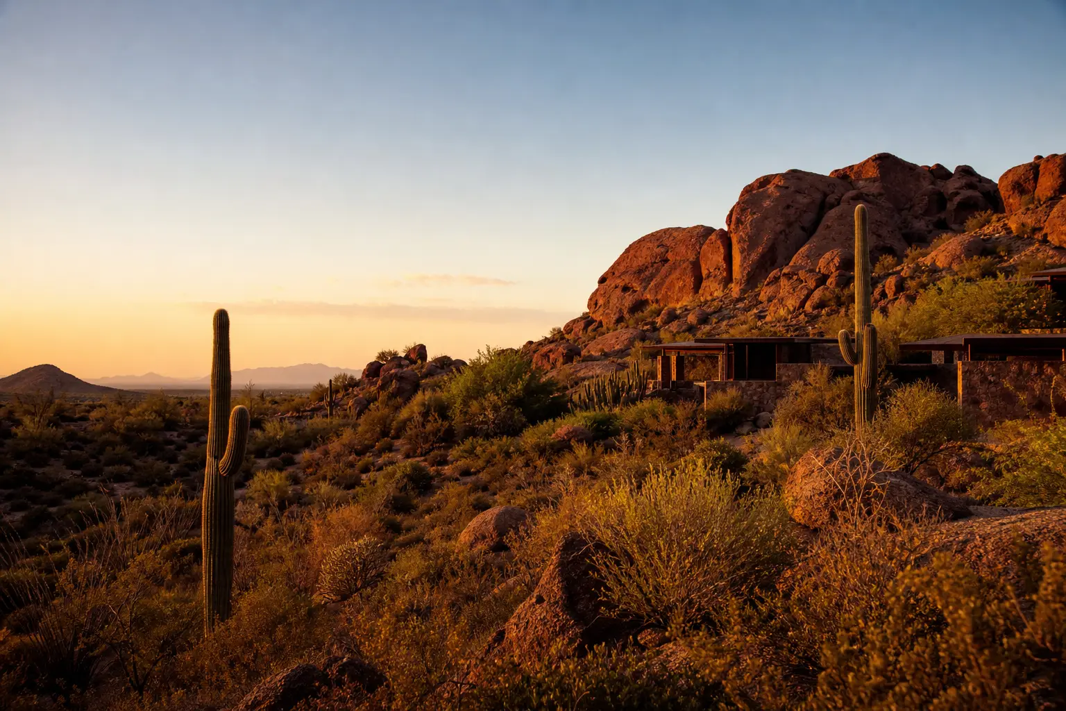A quiet desert retreat at golden hour with red rock formations, saguaro cacti, and a calm open sky