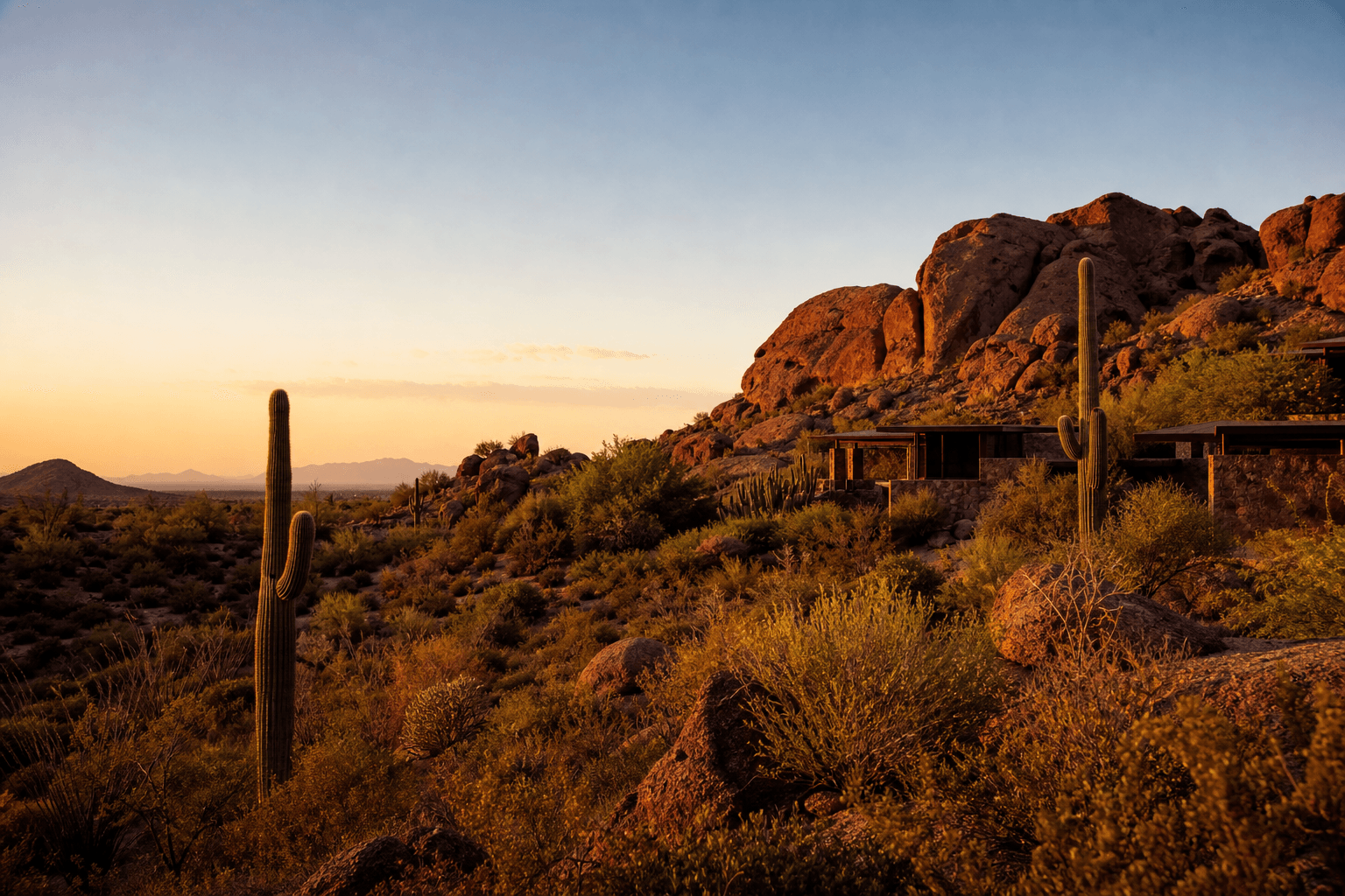 A quiet desert retreat at golden hour with red rock formations, saguaro cacti, and a calm open sky