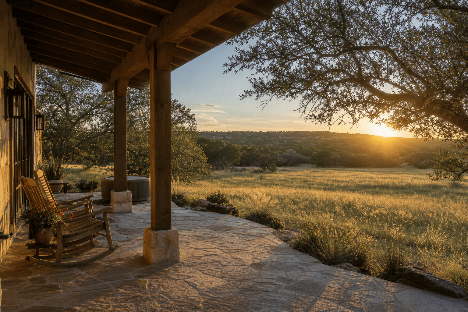A quiet ranch-style retreat porch overlooking Texas Hill Country meadows and oak trees at golden hour