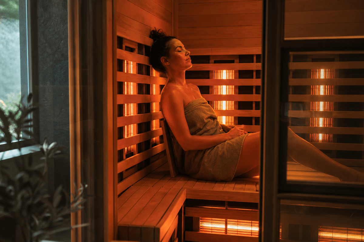 The warm glowing interior of an infrared sauna cabin with wooden benches