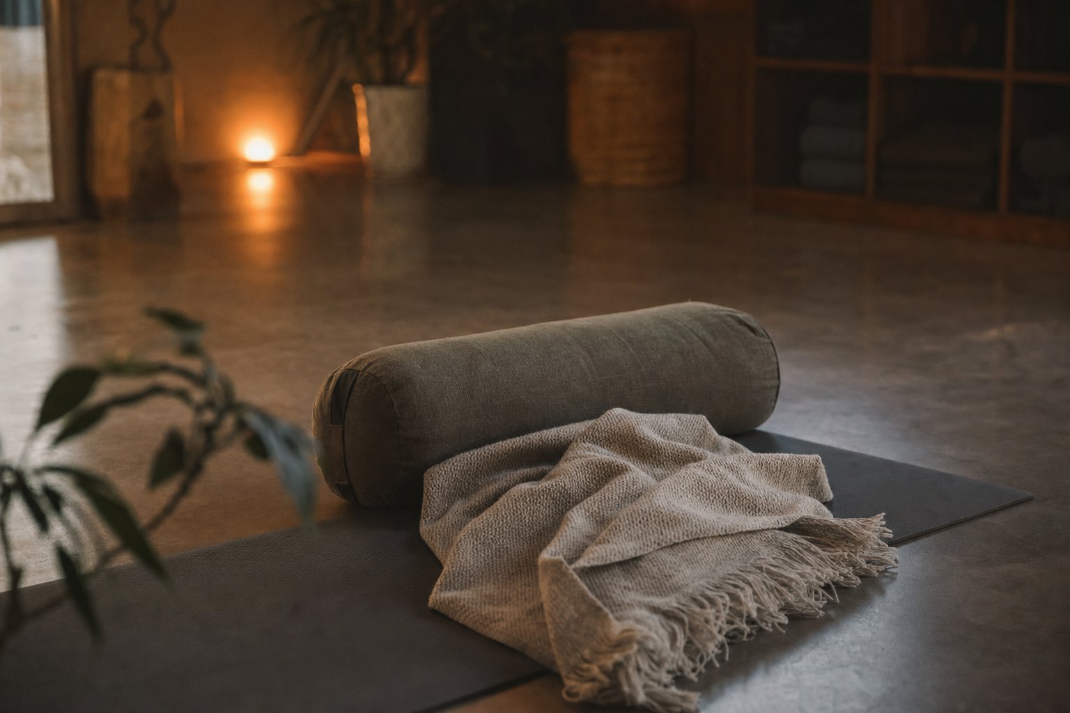 A person resting on their back under a blanket in a calm, dim room