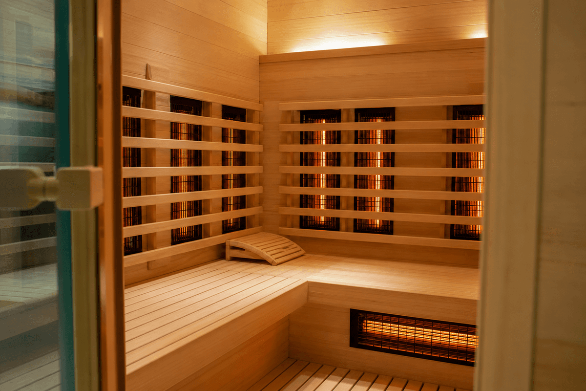 The warm wood-lined interior of an infrared sauna cabin with soft light